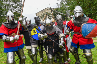 Group of people dresses in armour with swords and shields