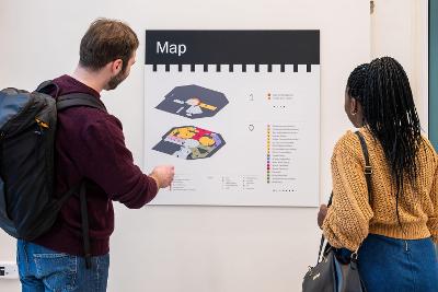 Two people looking at a map on the wall