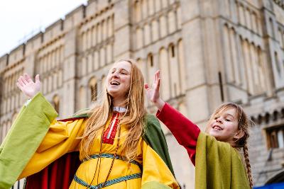 Woman and child dressed at medieval characters in front of castle