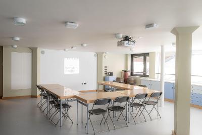 Room with horseshoe seating layout and desks
