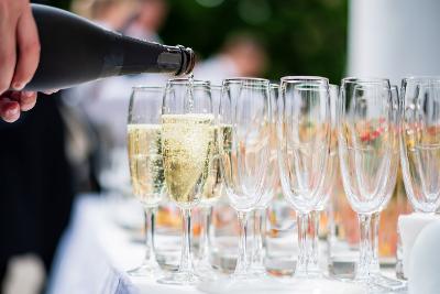 Champagne being poured into flutes set out on a white tablecloth